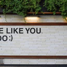 Frase “We like you, too” numa parede